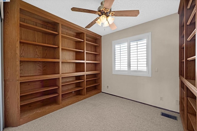 interior space with ceiling fan and a textured ceiling