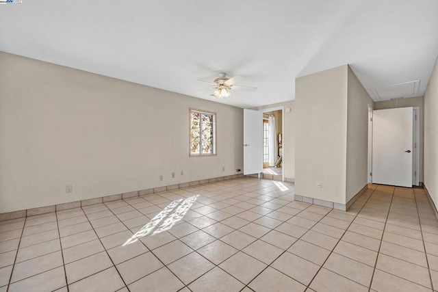 empty room with ceiling fan and light tile patterned floors