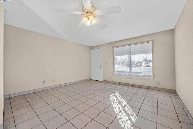 empty room featuring light tile patterned flooring and ceiling fan