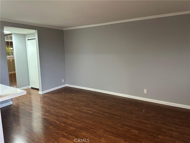 unfurnished room featuring dark wood-type flooring and ornamental molding