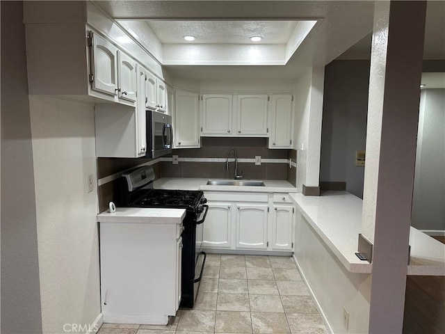 kitchen featuring sink, light tile patterned floors, black range with gas cooktop, white cabinetry, and a textured ceiling