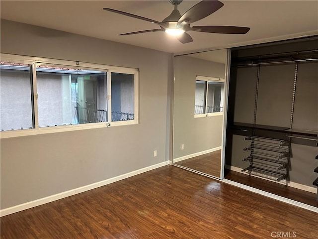 unfurnished bedroom featuring dark wood-type flooring, ceiling fan, and a closet