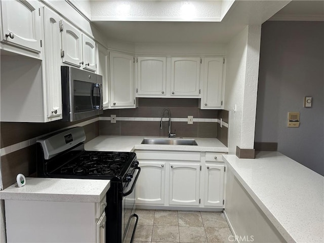 kitchen with appliances with stainless steel finishes, sink, and white cabinets