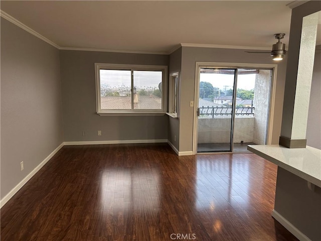 empty room featuring dark hardwood / wood-style flooring, ornamental molding, and ceiling fan