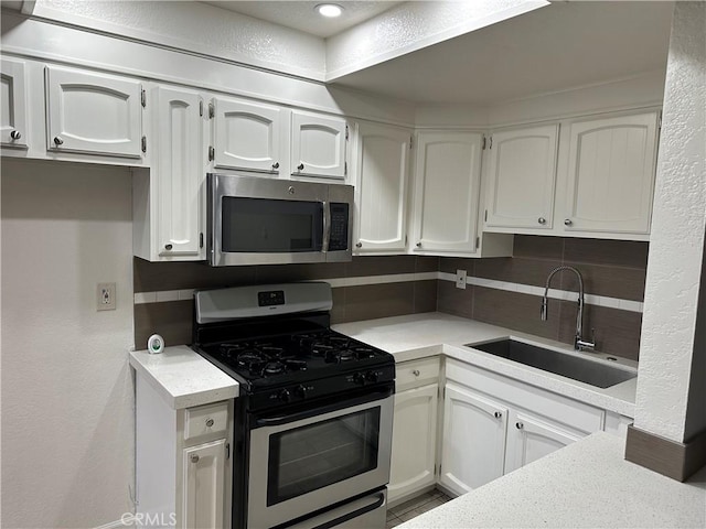 kitchen featuring white cabinetry, sink, decorative backsplash, and appliances with stainless steel finishes