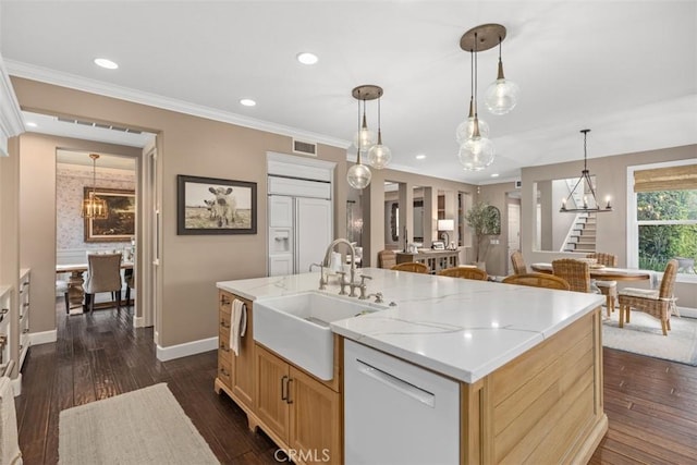 kitchen featuring pendant lighting, sink, dark wood-type flooring, an island with sink, and light brown cabinets