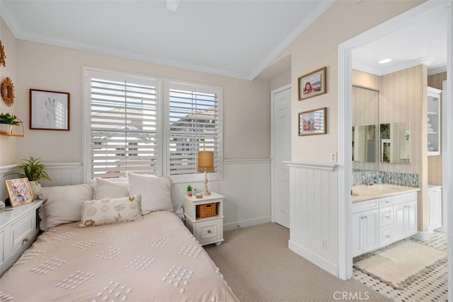 carpeted bedroom featuring crown molding and ensuite bath