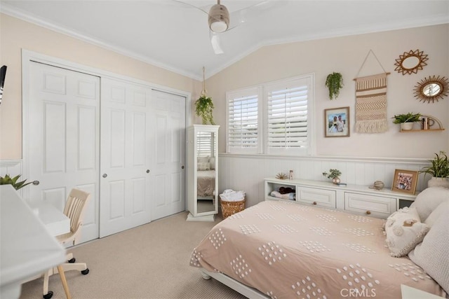 bedroom featuring light carpet, ceiling fan, a closet, vaulted ceiling, and crown molding