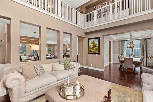 living room with wood-type flooring, a high ceiling, and a chandelier