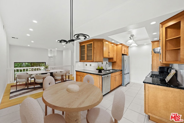 kitchen featuring appliances with stainless steel finishes, light tile patterned floors, pendant lighting, sink, and backsplash