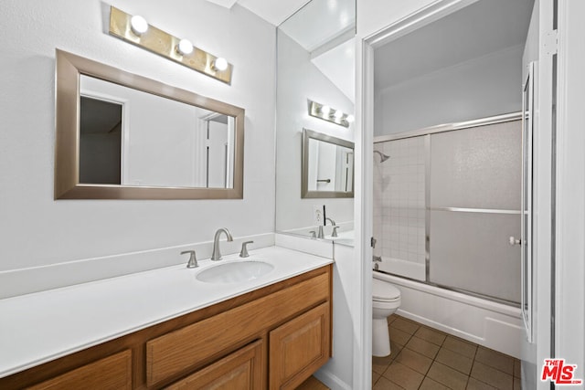 full bathroom featuring toilet, lofted ceiling, bath / shower combo with glass door, tile patterned floors, and vanity