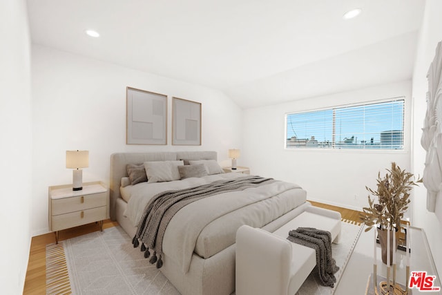 bedroom with light hardwood / wood-style flooring and lofted ceiling