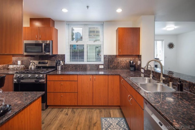 kitchen featuring a healthy amount of sunlight, light wood-type flooring, appliances with stainless steel finishes, and sink