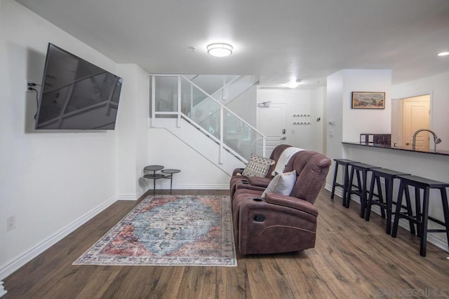 living room with dark hardwood / wood-style floors and sink