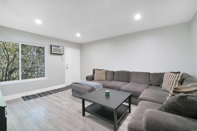 living room featuring light hardwood / wood-style floors and a wall mounted AC