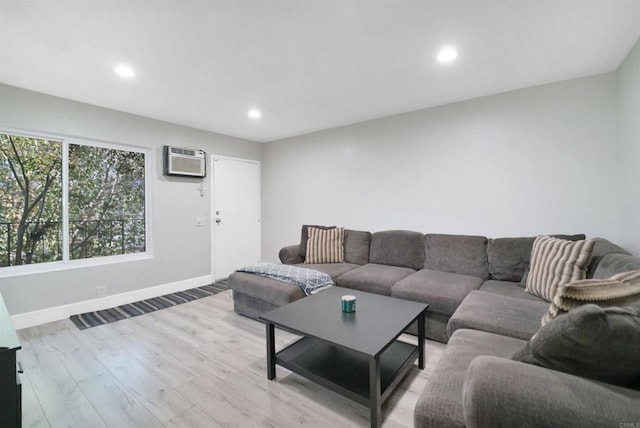 living room with light hardwood / wood-style floors and a wall mounted air conditioner