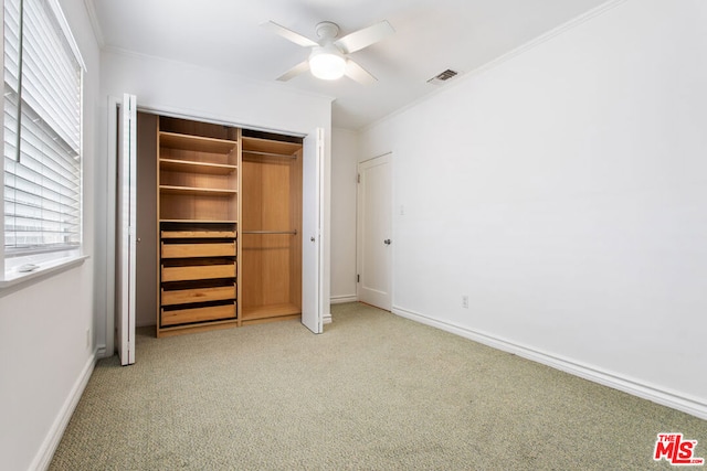 unfurnished bedroom with a closet, ceiling fan, carpet flooring, and multiple windows