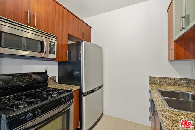 kitchen featuring light stone counters, light tile patterned floors, and appliances with stainless steel finishes