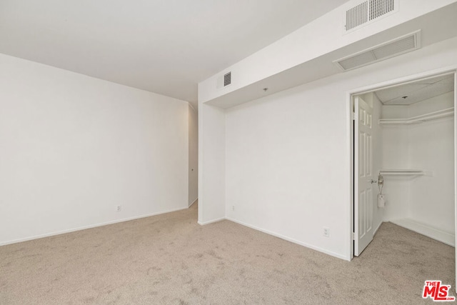 unfurnished room featuring light colored carpet