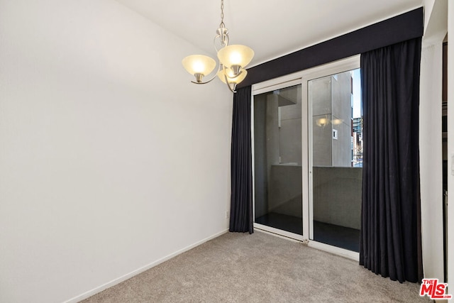 carpeted empty room featuring an inviting chandelier