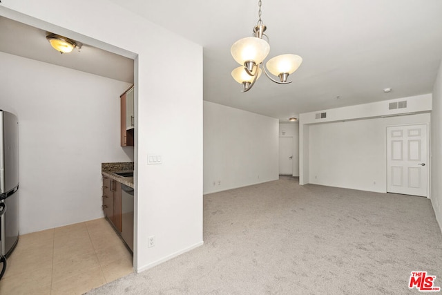 kitchen with hanging light fixtures, appliances with stainless steel finishes, light carpet, and a chandelier