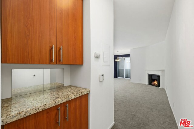 kitchen featuring carpet flooring and light stone counters