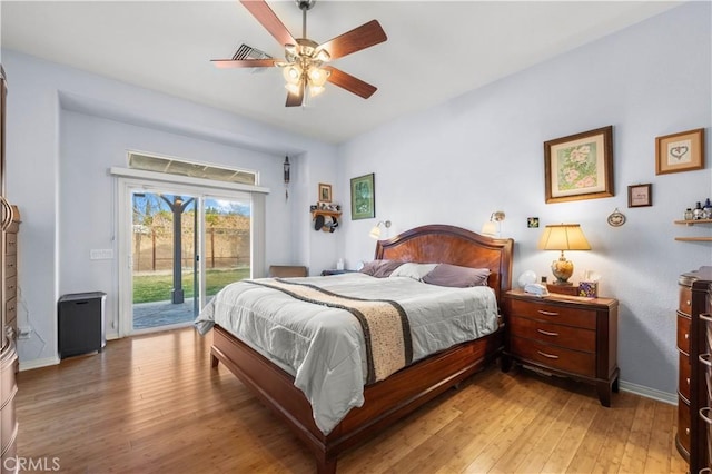 bedroom with ceiling fan, access to exterior, and wood-type flooring