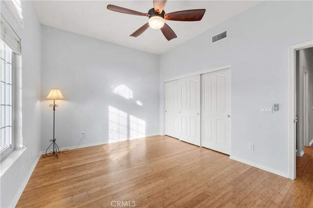 unfurnished bedroom featuring ceiling fan, light hardwood / wood-style floors, and a closet