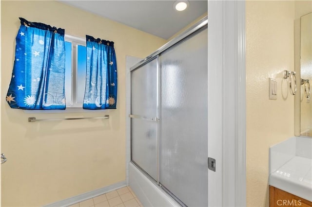 bathroom with bath / shower combo with glass door and tile patterned flooring