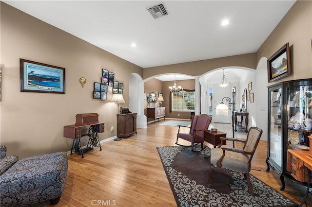 sitting room featuring a notable chandelier and light wood-type flooring