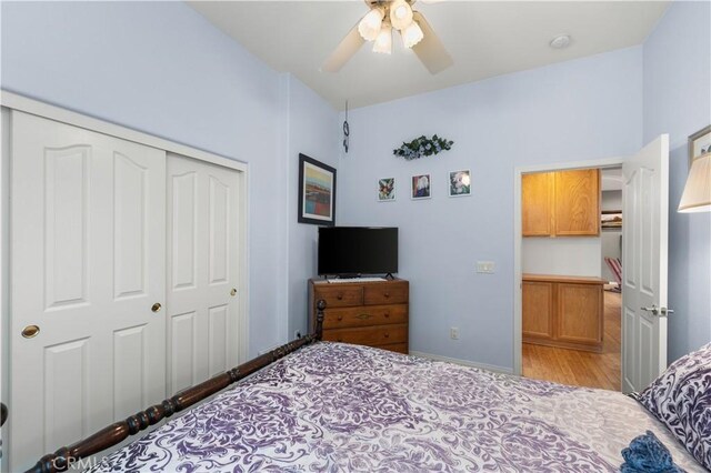 bedroom featuring ceiling fan, a closet, and light wood-type flooring