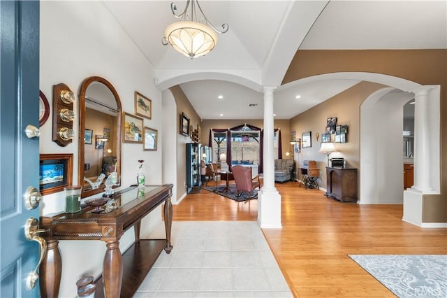 foyer featuring light hardwood / wood-style floors, ornate columns, and a fireplace