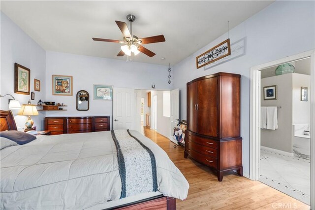 bedroom with light wood-type flooring, ceiling fan, and ensuite bath