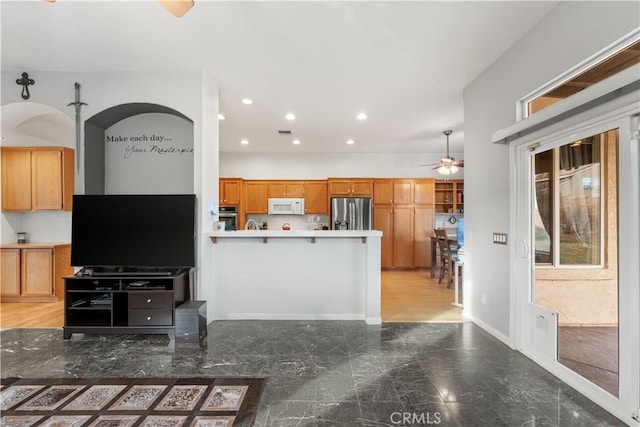 kitchen with ceiling fan, appliances with stainless steel finishes, and kitchen peninsula