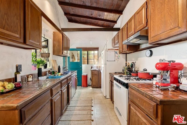 kitchen with range hood, lofted ceiling with beams, white range with gas cooktop, wood ceiling, and tile counters