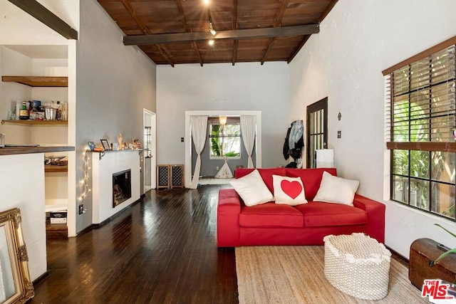 living room featuring a healthy amount of sunlight, wood ceiling, beamed ceiling, and dark hardwood / wood-style flooring