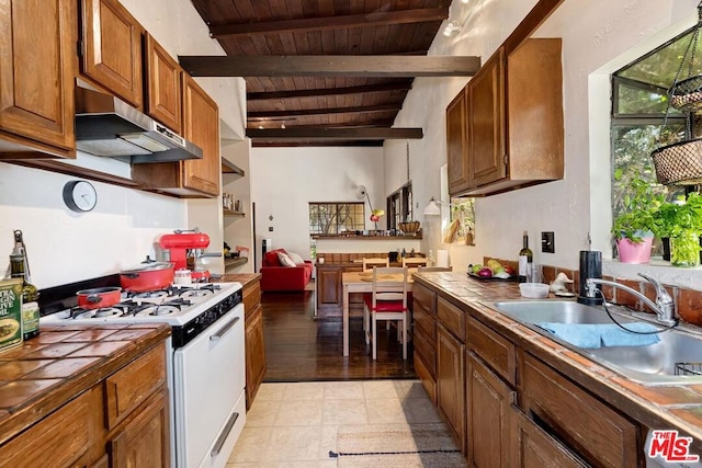 kitchen with wooden ceiling, tile counters, ventilation hood, and white gas stove