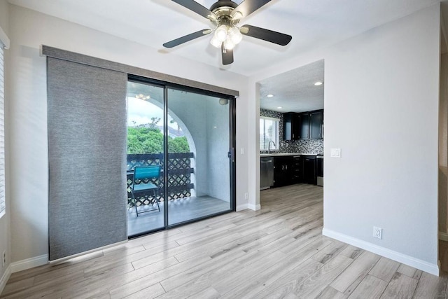 empty room featuring ceiling fan, sink, and light hardwood / wood-style flooring