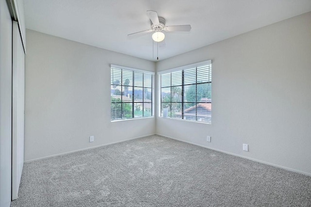 carpeted spare room featuring ceiling fan