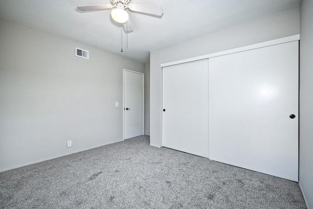 unfurnished bedroom with ceiling fan, a closet, and carpet floors