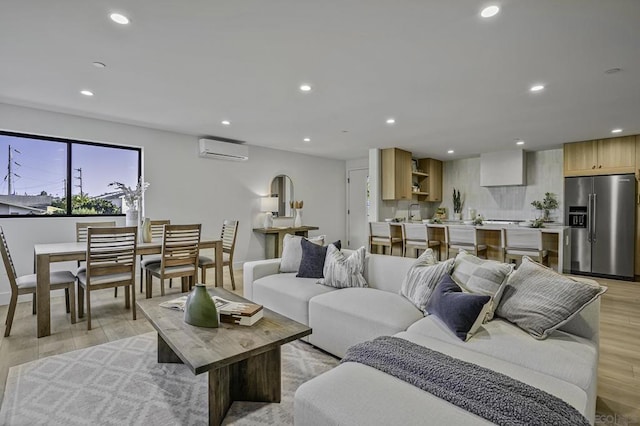 living room featuring light wood-type flooring and a wall unit AC