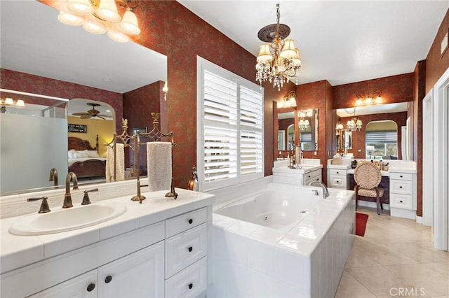 bathroom featuring vanity, tiled tub, ceiling fan with notable chandelier, and tile patterned floors