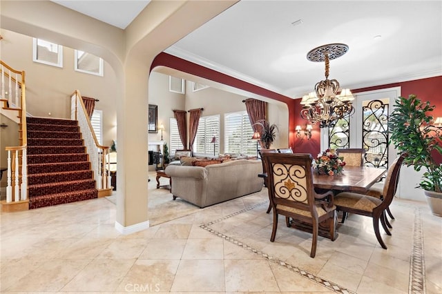 tiled dining area featuring ornamental molding and a notable chandelier