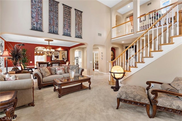 carpeted living room featuring a towering ceiling and a chandelier