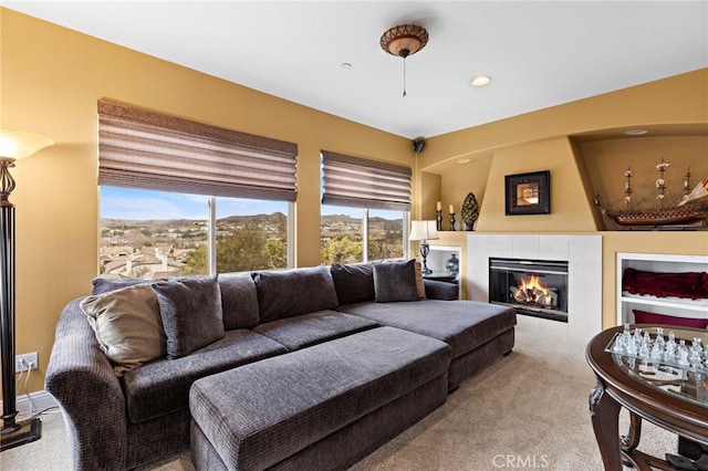 carpeted living room featuring a tile fireplace