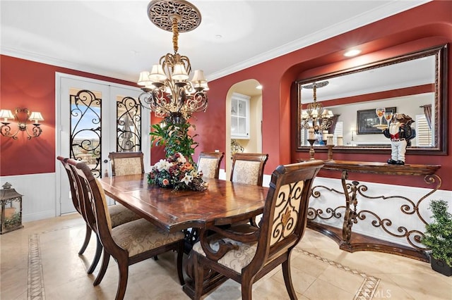 dining room with french doors, ornamental molding, and a chandelier