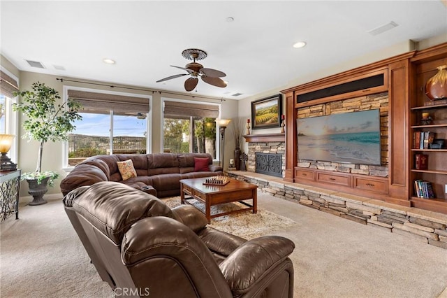 carpeted living room with a fireplace and ceiling fan