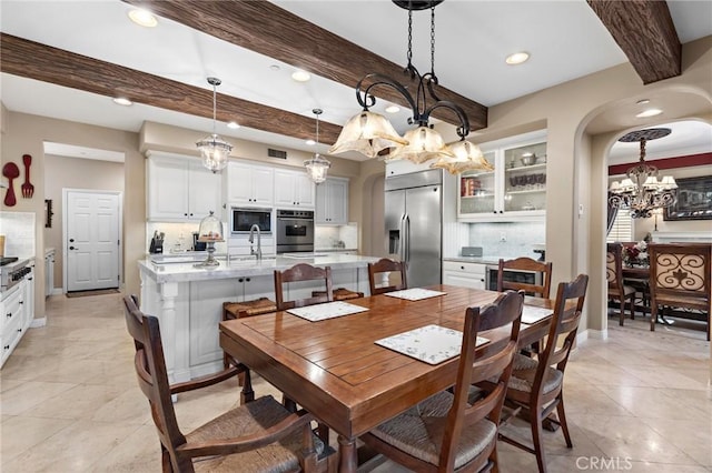 dining room with beam ceiling and sink