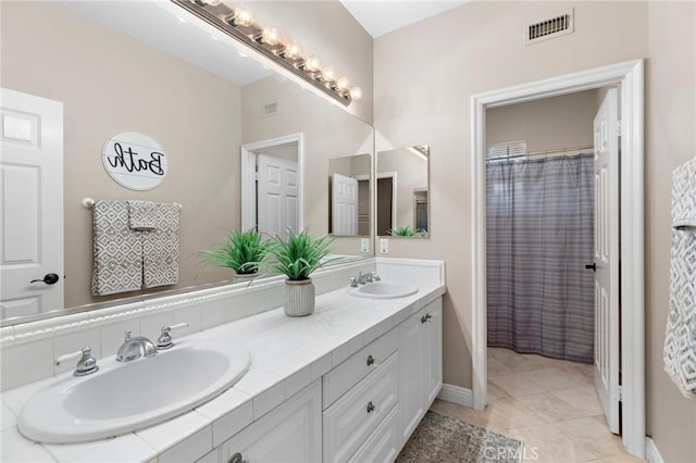 bathroom with a shower with shower curtain, vanity, and tile patterned flooring