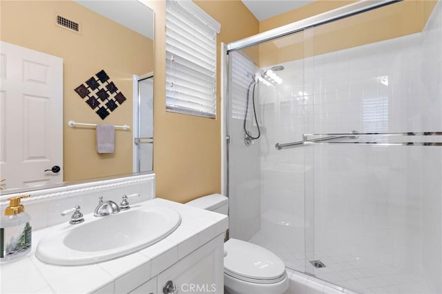 bathroom with walk in shower, vanity, and toilet